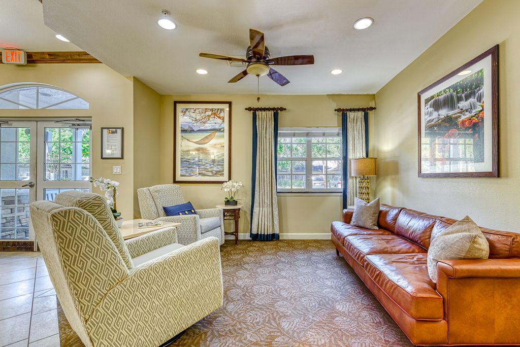 A cozy living room featuring comfortable seating, decorative artwork, and natural lighting.