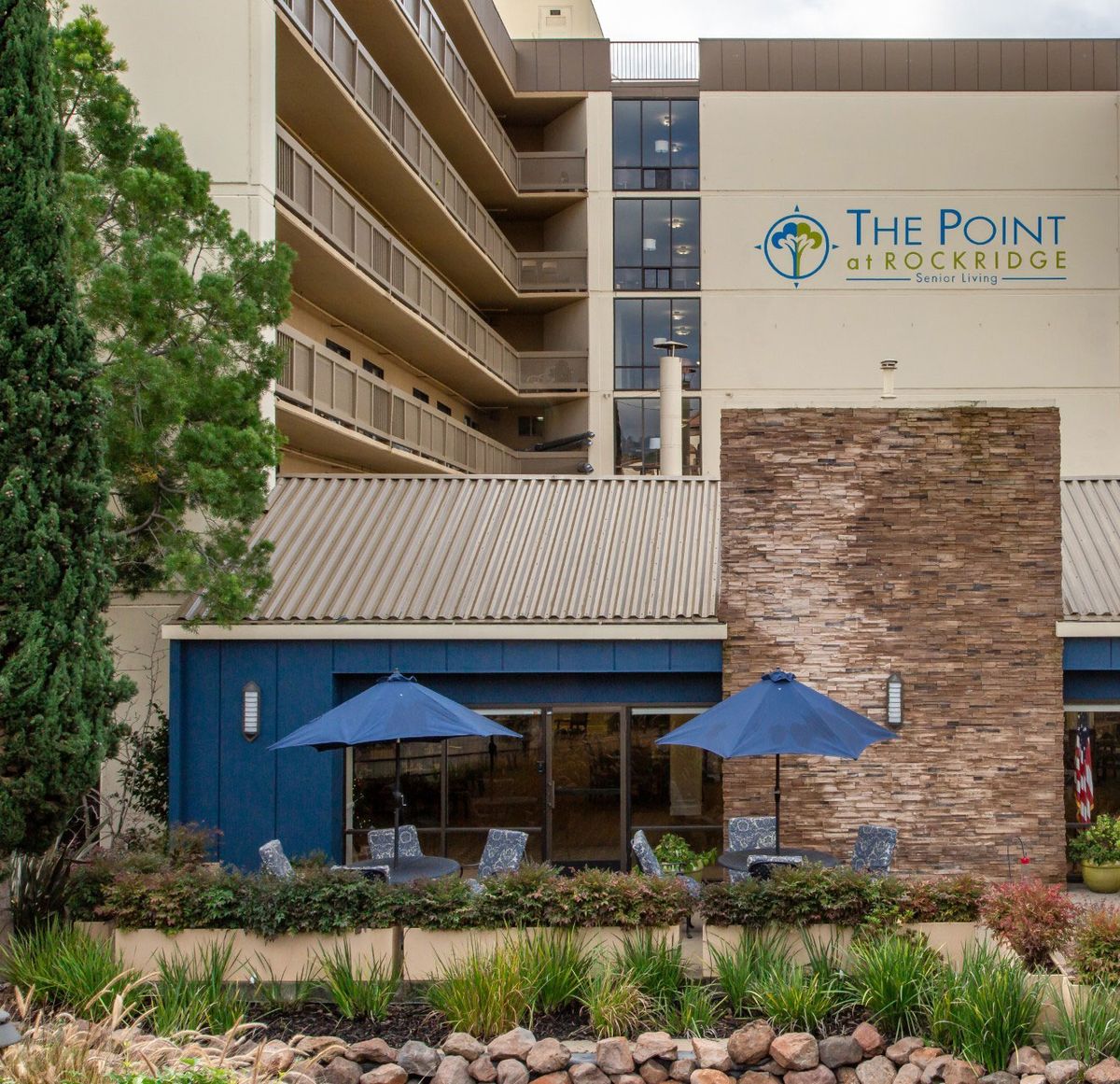 The Point Hotel features outdoor seating with umbrellas amidst well-maintained landscaping.