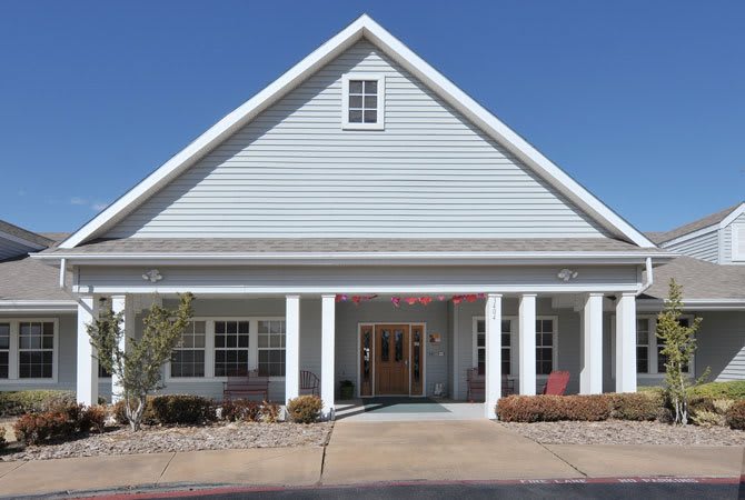 Front view of a residential style building with a gable roof and columns.