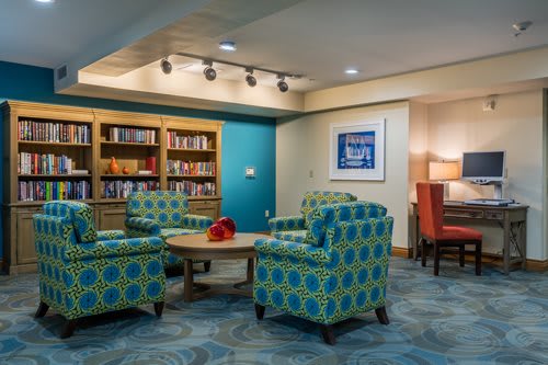 A cozy library seating area with patterned armchairs and bookshelves.