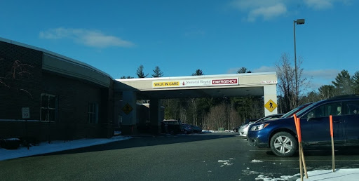 A view of a business entrance with clear blue skies and parked cars.