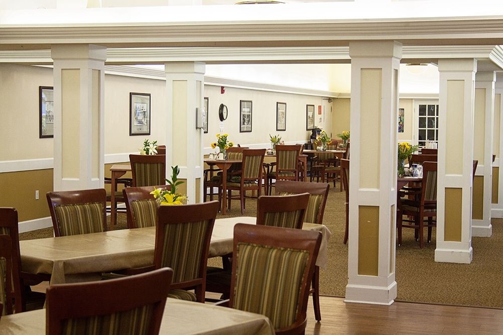 An empty dining room with neatly arranged tables and chairs.