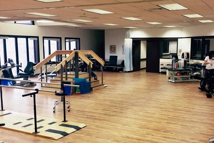 A spacious physical therapy room with various rehabilitation equipment.