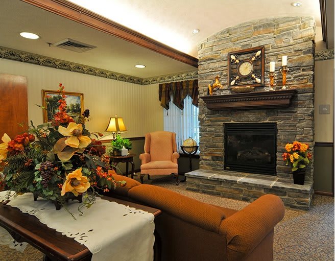 A cozy living room with a stone fireplace and elegant furniture.
