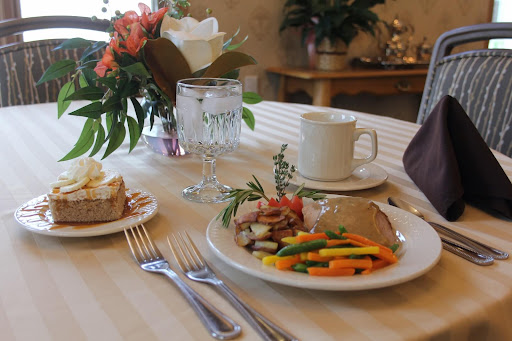 A beautifully set table featuring a delicious meal with colorful vegetables and fresh flowers.