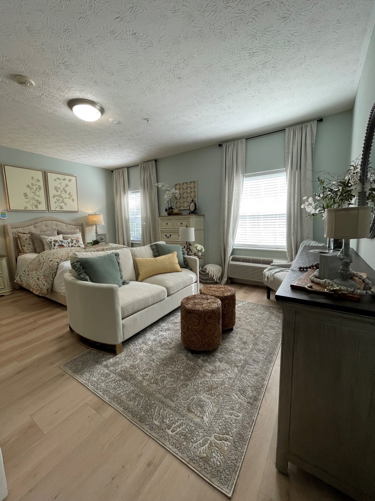 A cozy bedroom with elegant decor, featuring a bed, sofa, and stylish furnishings.