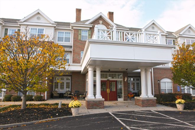 Front entrance of a multi-story building with columns and large windows.