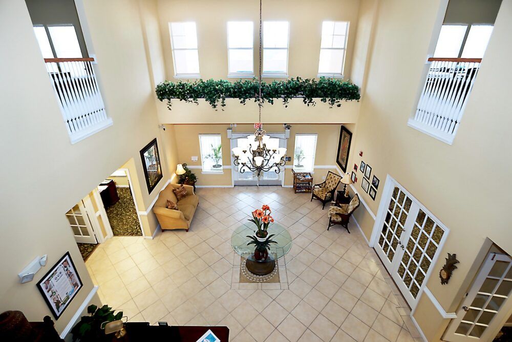 A spacious and elegantly decorated lobby with a chandelier, large windows, and comfortable seating.
