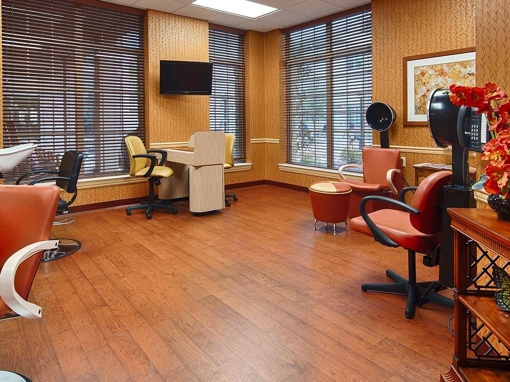 An empty hair salon with chairs, mirrors, and a wooden floor.