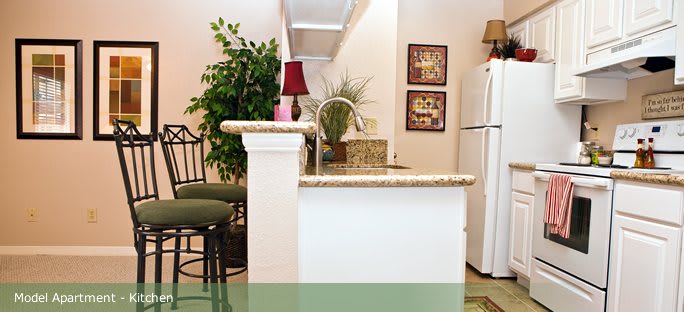 A cozy kitchen space with a bar counter, stools, and decorative elements.