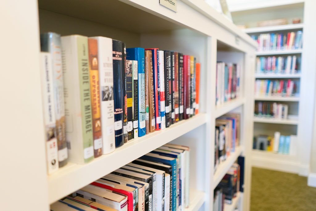 A library bookshelf filled with various books of different genres.