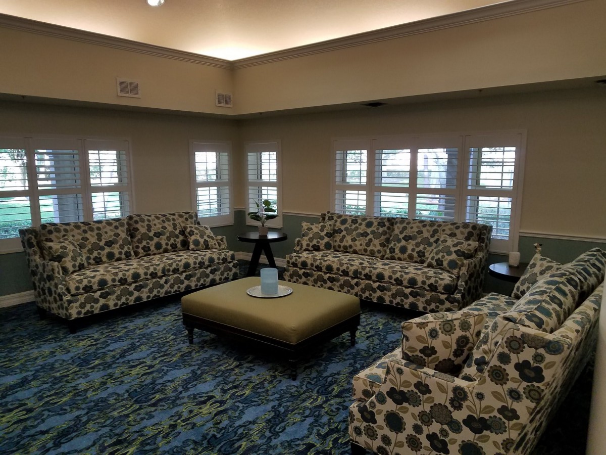A cozy living room with patterned sofas and a central ottoman.