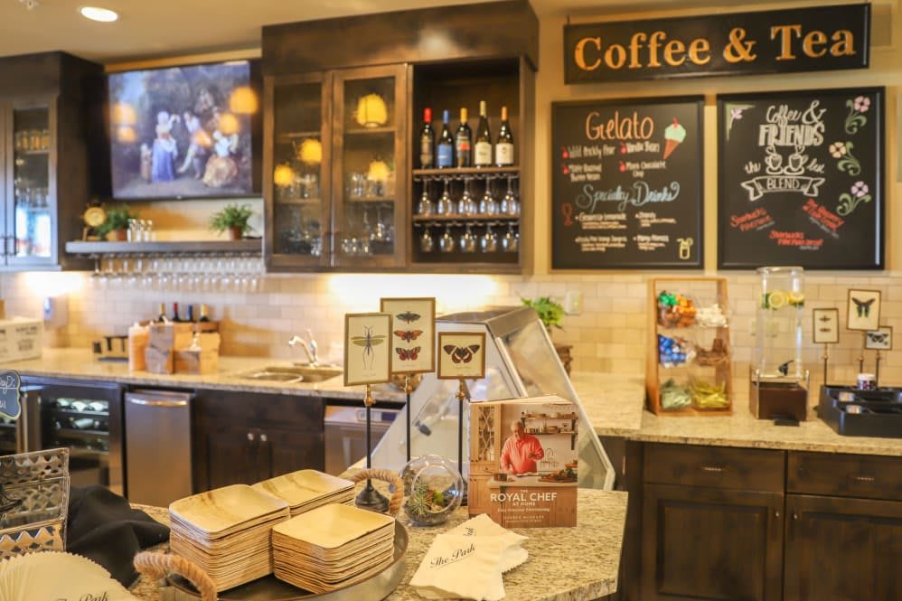 A cozy coffee shop interior featuring a chalkboard menu and wine display.