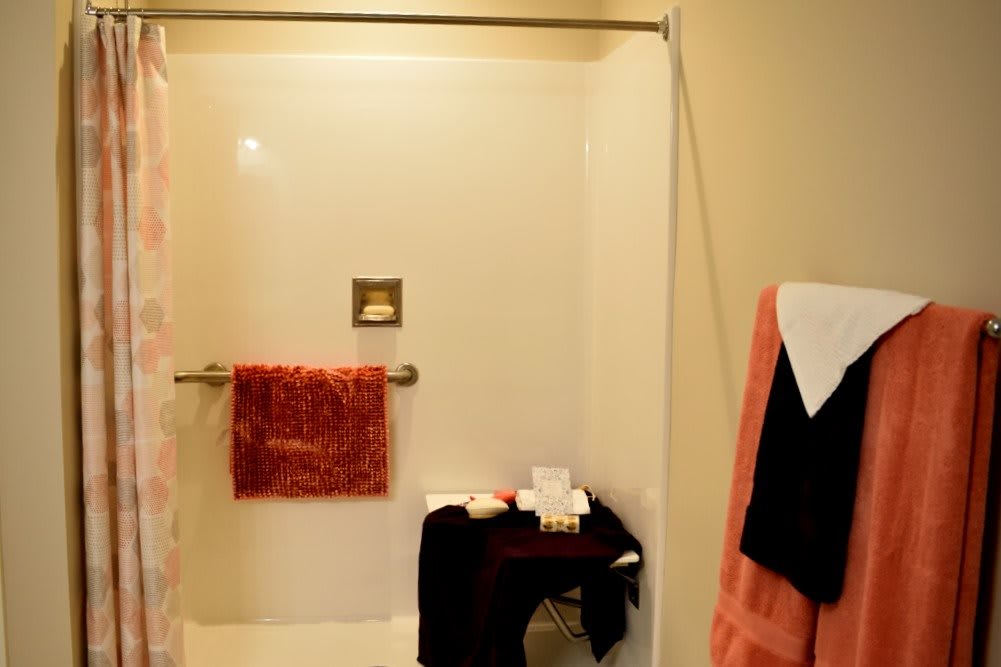 A cozy bathroom with a shower and neatly arranged towels.