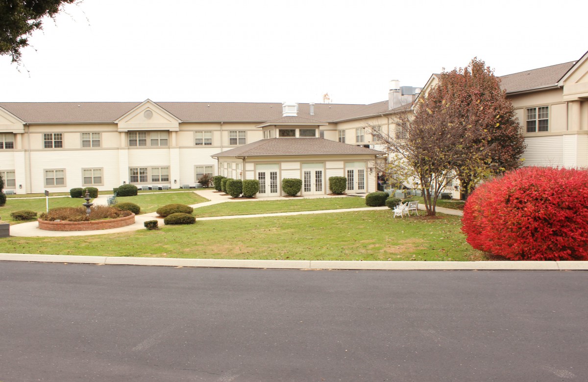 A residential building with well-maintained landscaping and a spacious lawn.