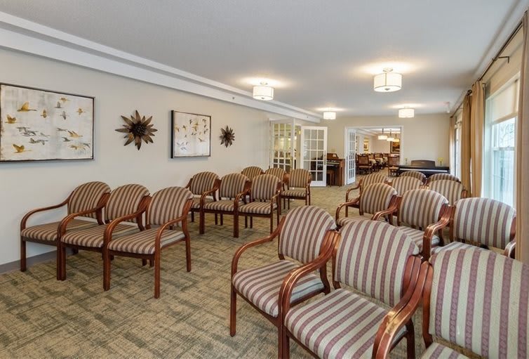 A neatly arranged conference room with striped chairs and decorative wall art.