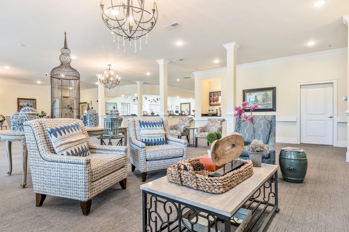 A beautifully designed living room with elegant chandeliers, stylish furniture, and bright lighting.
