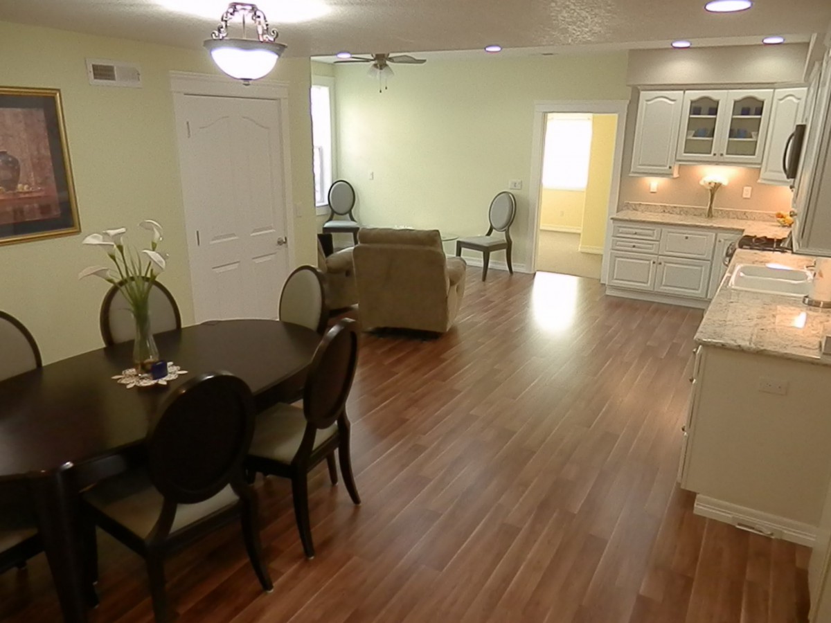 Open concept living and dining area with hardwood floors and modern furnishings.