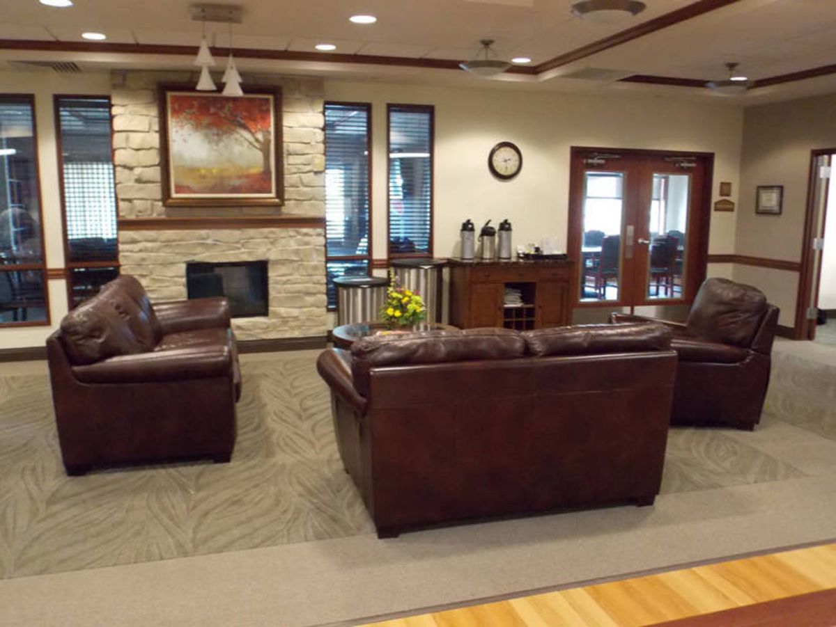 A welcoming lobby with leather couches and a fireplace alongside a coffee station.
