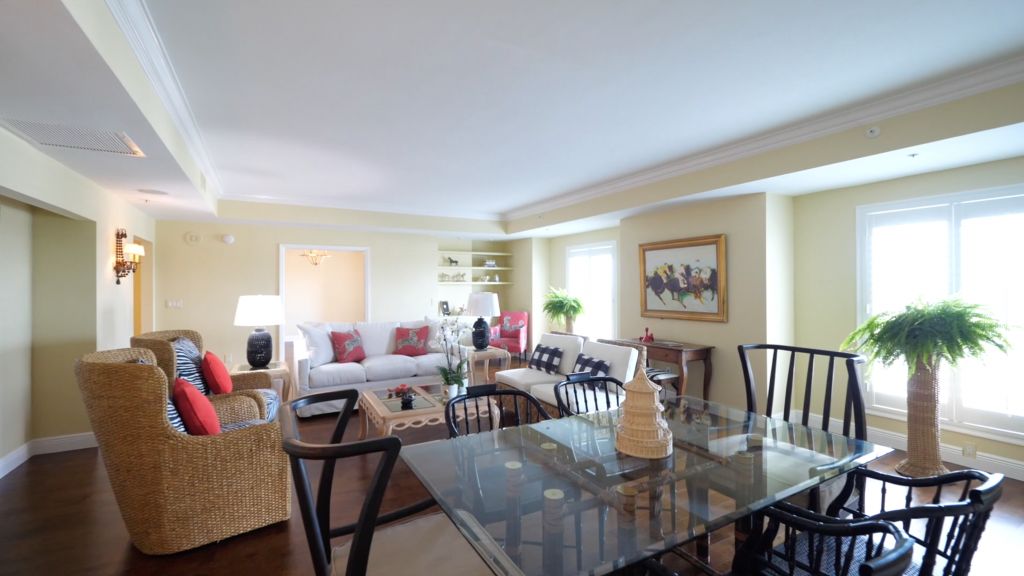 A cozy living and dining area featuring a glass table, comfortable seating, and tasteful decor.