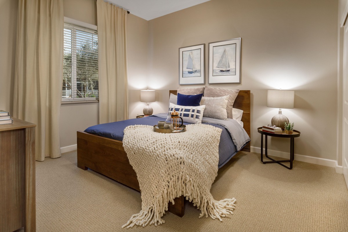A cozy, well-decorated bedroom with a neatly made bed and soft lighting.