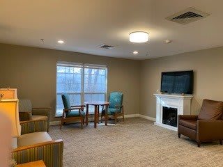 A cozy living room with a television, fireplace, and seating area.