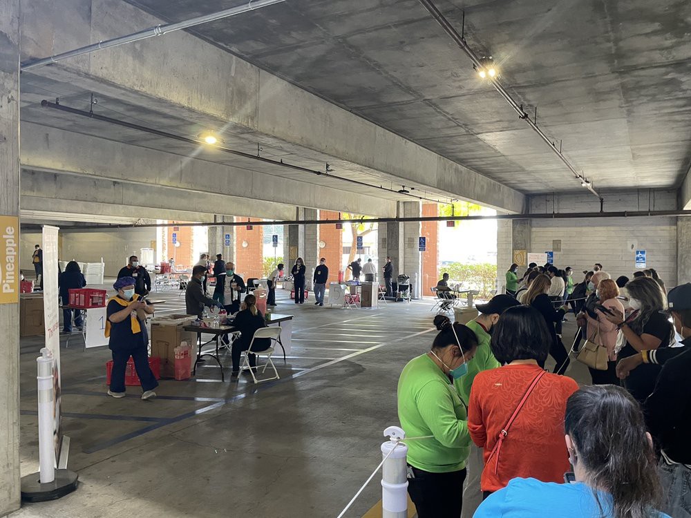 A group of people gathered in an indoor space with tables and chairs, possibly for a meeting or event.