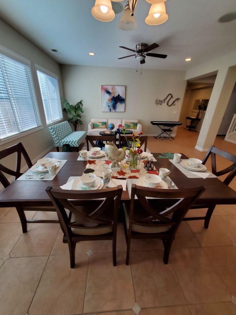 A well-set dining room table prepared for a meal, featuring stylish decor and comfortable seating.
