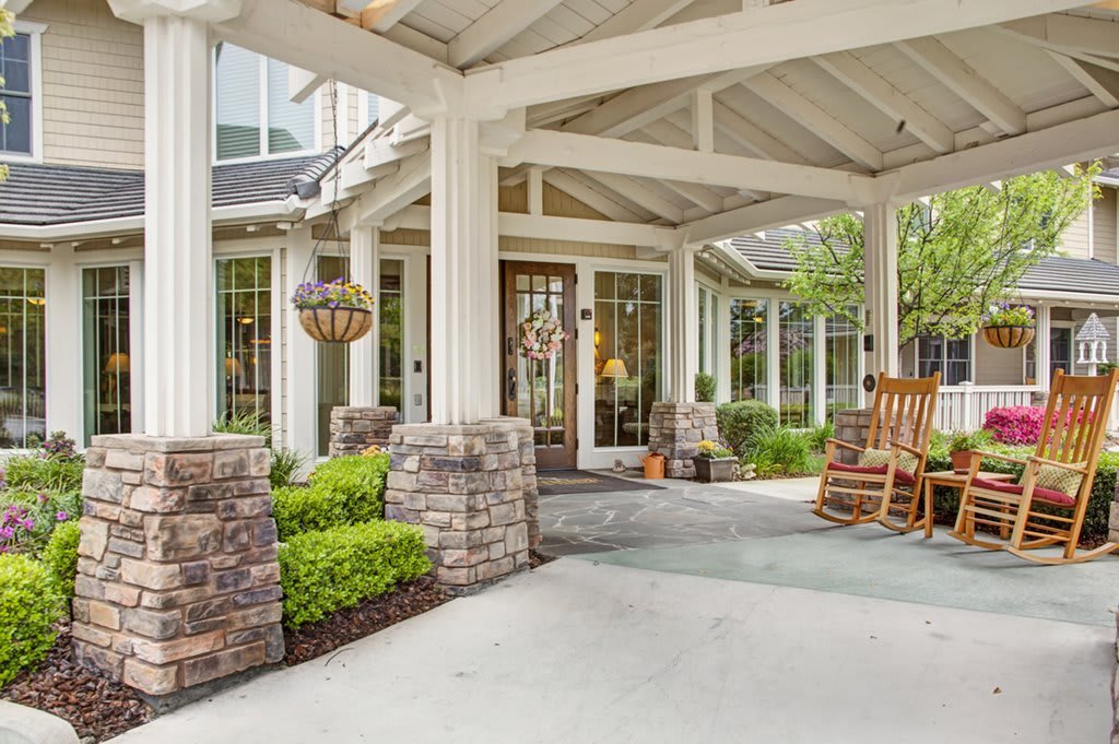 A welcoming porch with a rocking chair and elegant landscaping.