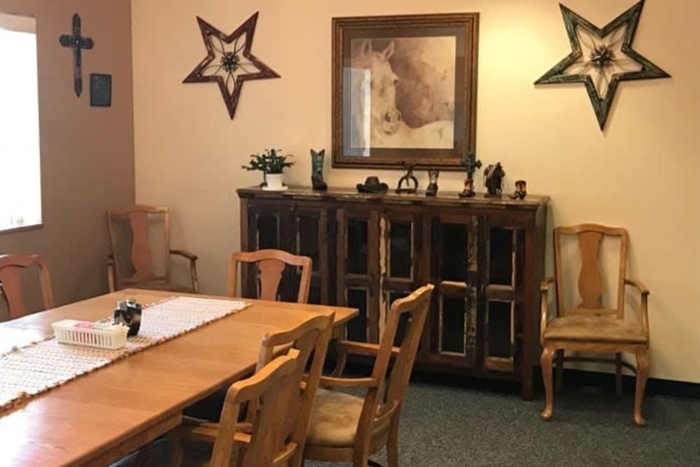 A cozy dining room with wooden furniture and decorative wall art.