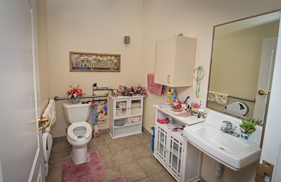 A well-organized bathroom with pink accents and ample storage.