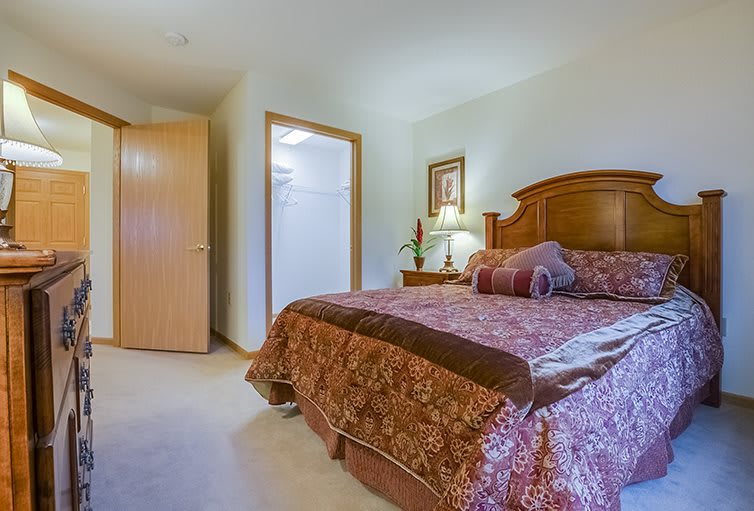 A cozy bedroom with a wooden bed frame and warm decor.