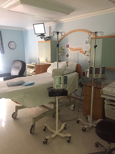 A hospital patient room equipped with a bed, medical devices, and an IV stand.