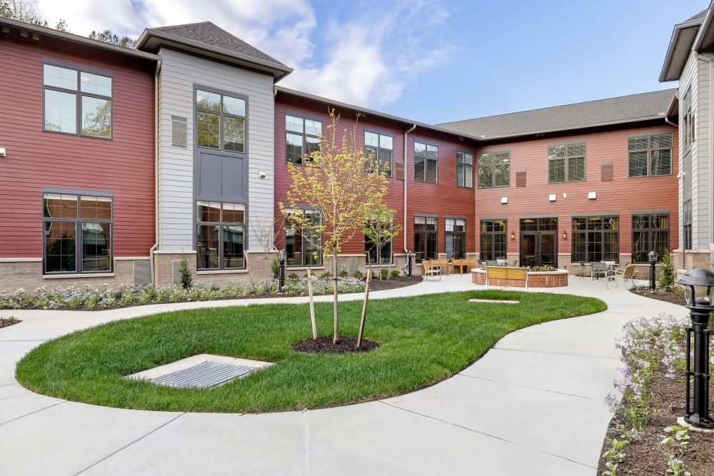 A modern building features a spacious courtyard with landscaped grass and walking paths.