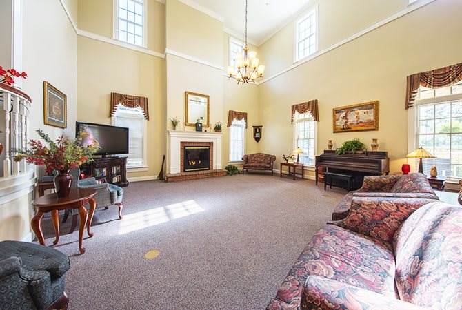 Spacious living room with high ceilings, a grand chandelier, and elegant furnishings.