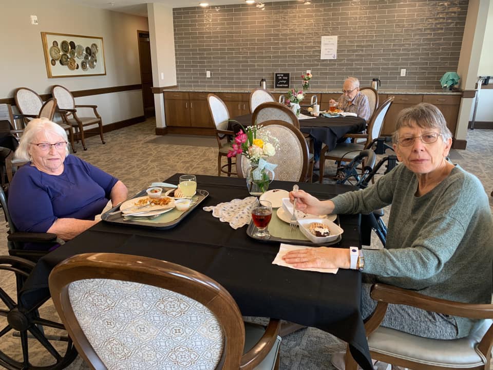 Two people dining at a restaurant, enjoying their meals indoors.