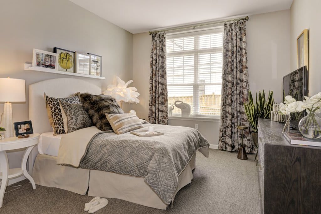 A cozy bedroom with elegant decor and a large window letting in natural light.