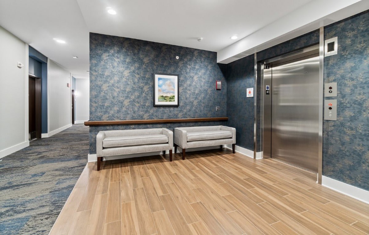 Modern lobby with seating area and elevator.