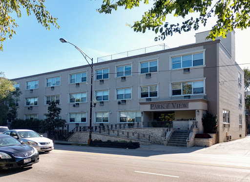A modern multi-story building with large windows, located on a sunny day.