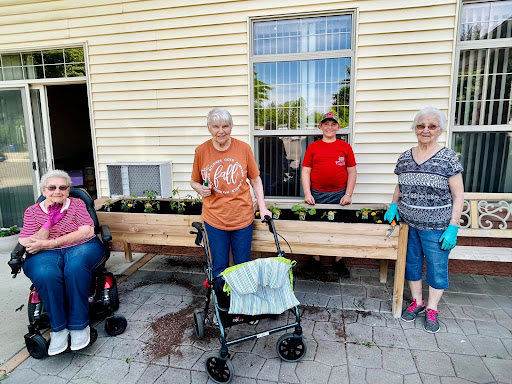 A group of elderly individuals enjoying a community gardening activity together.