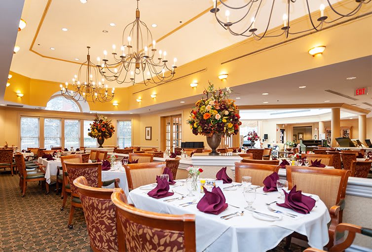 An elegant dining room with chandeliers and decorative table settings.