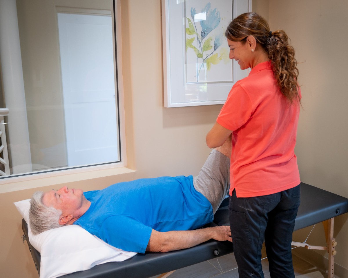 A therapist assists a patient during a physical therapy session.