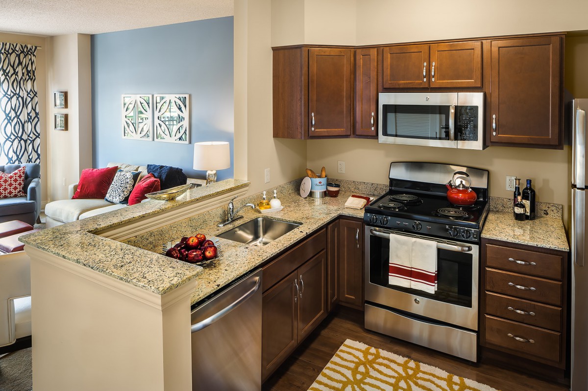 A modern kitchen with stainless steel appliances and wood cabinets.