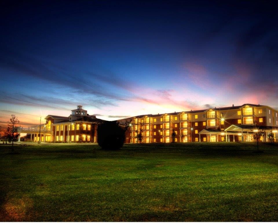 A well-lit building against a colorful evening sky.