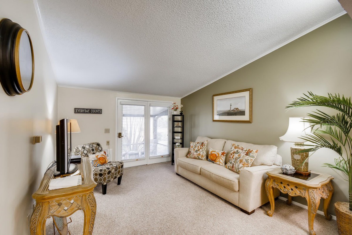 A cozy living room with a beige sofa, patterned chairs, and decorative accents.