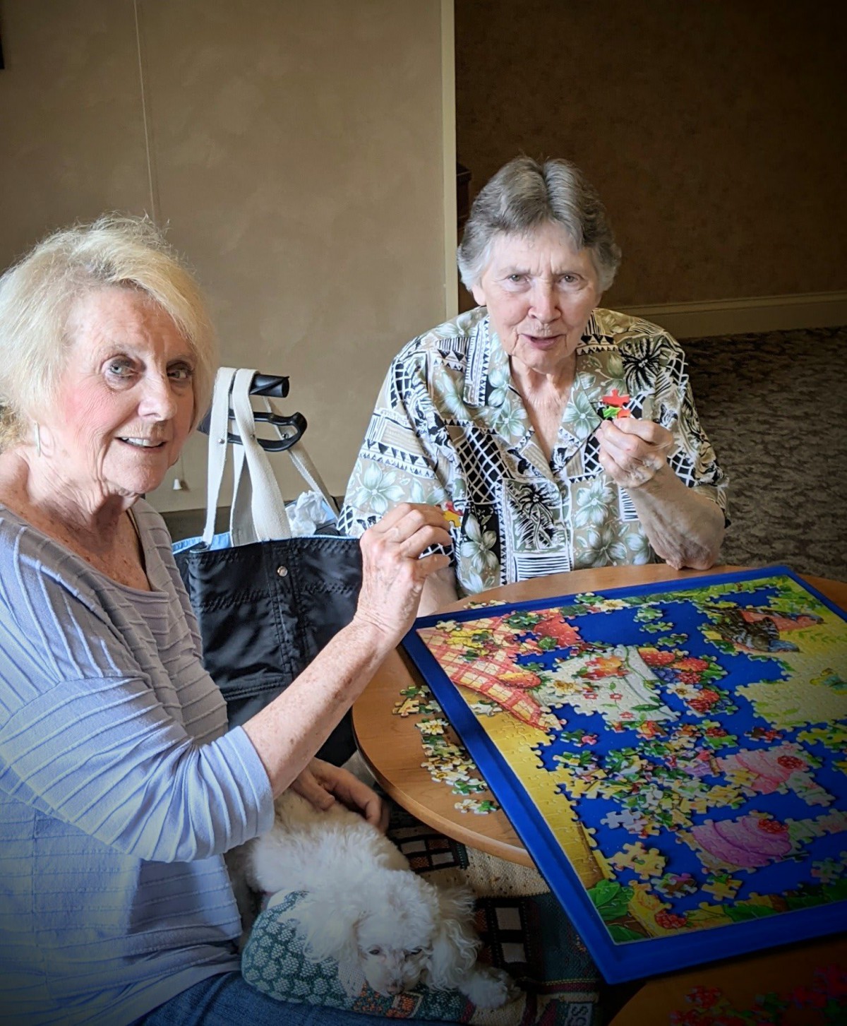 Two seniors working together on a colorful puzzle.