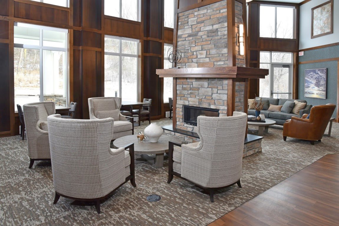 A modern lobby with a cozy seating area around a central fireplace.