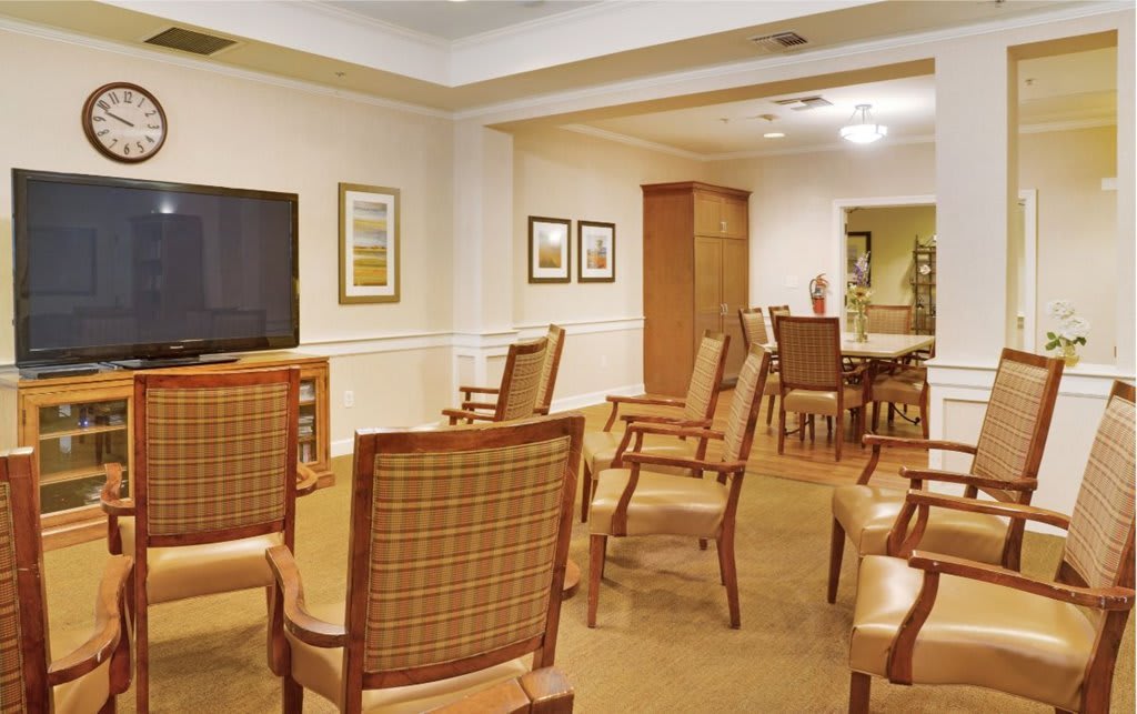 A cozy conference room with arranged seating and a large television.
