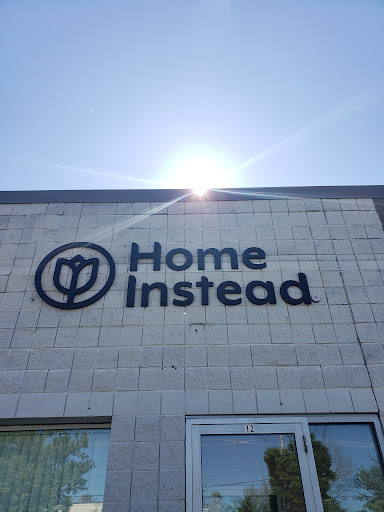 The exterior of a Home Instead location, with the sun shining above.