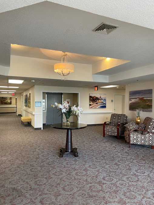 A spacious lobby with seating area, decorative lighting, and artwork on the walls.